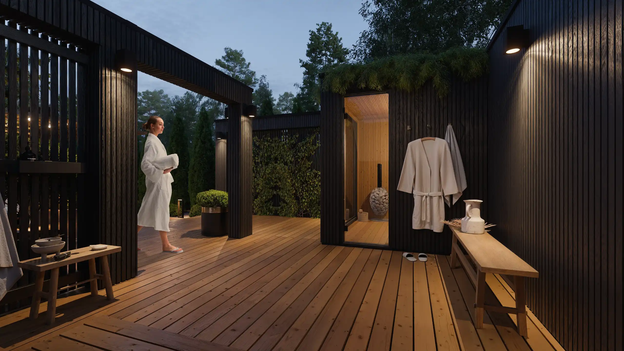 Nowoczesna strefa wellness spa z sauną ogrodową wieczorem. Projekt intymnego tarasu wypoczynkowego, zewnętrzna strefa schładzania z prysznicem, wieszakiem na szlafroki, ławką i iluminacją świetlną kinkietów – NAIMAD STUDIO.